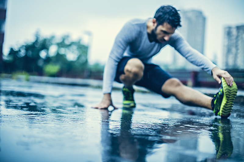 man stretching in rain